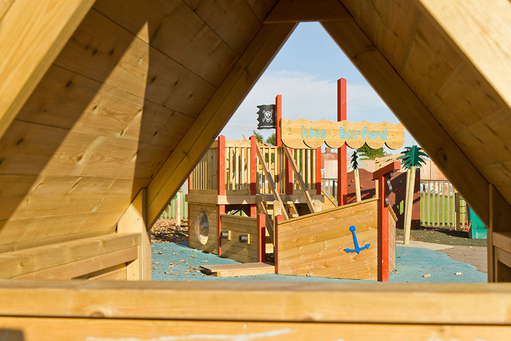 Playground apparatus with wooden pirate ship and shelter